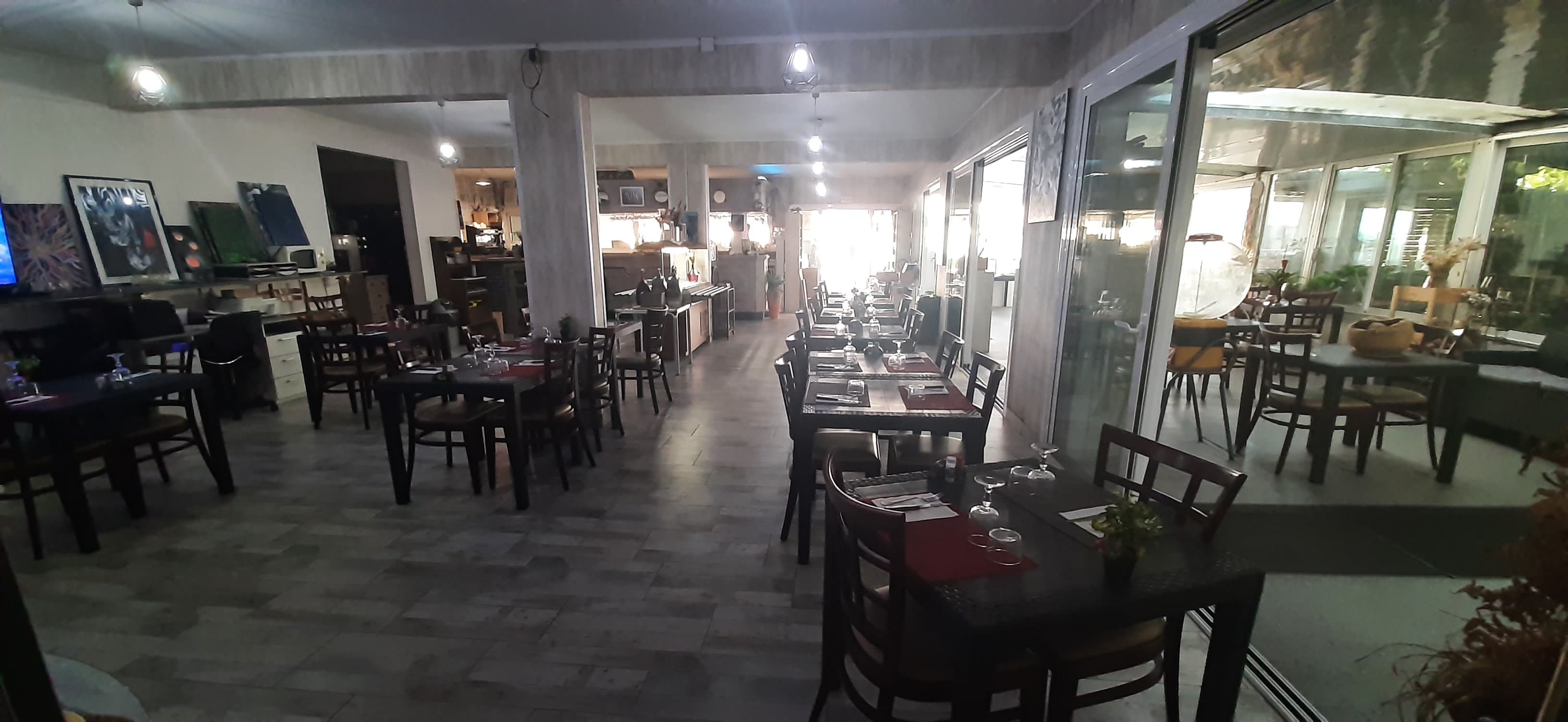 Main dining room of the Catamaran seen from the back, tables set